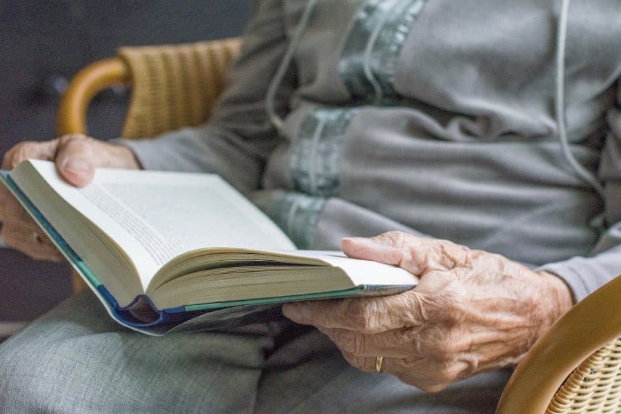 Séniors qui lit un livre. La sophrologie aide à renforcer sa mémoire.
