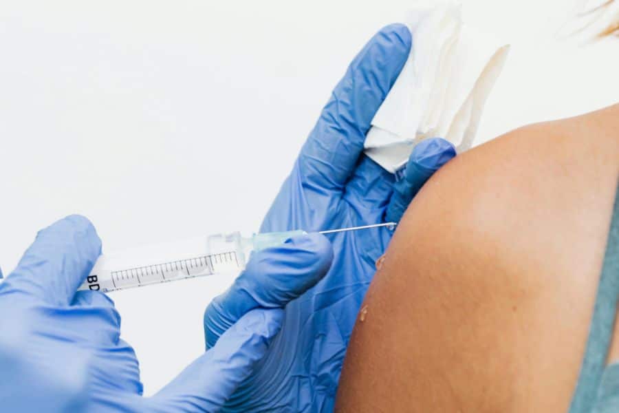 Une jeune femme se préparant à recevoir une piqûre qui peut être pour certains désagréable.