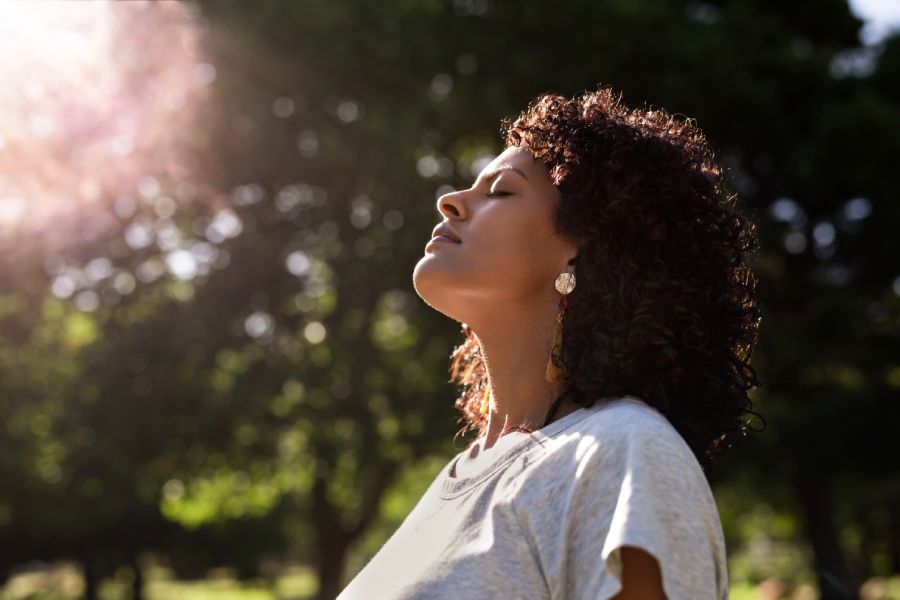 Jeune femme respirant pleinement comme dans une sophro-balade